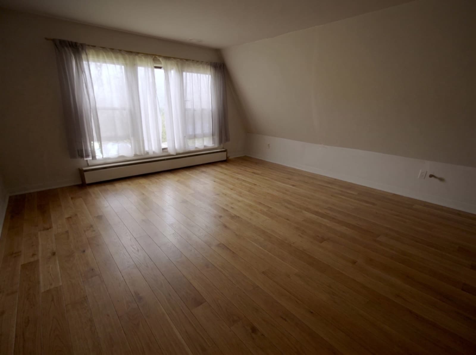 Same living room with newly installed honey-toned oak hardwood