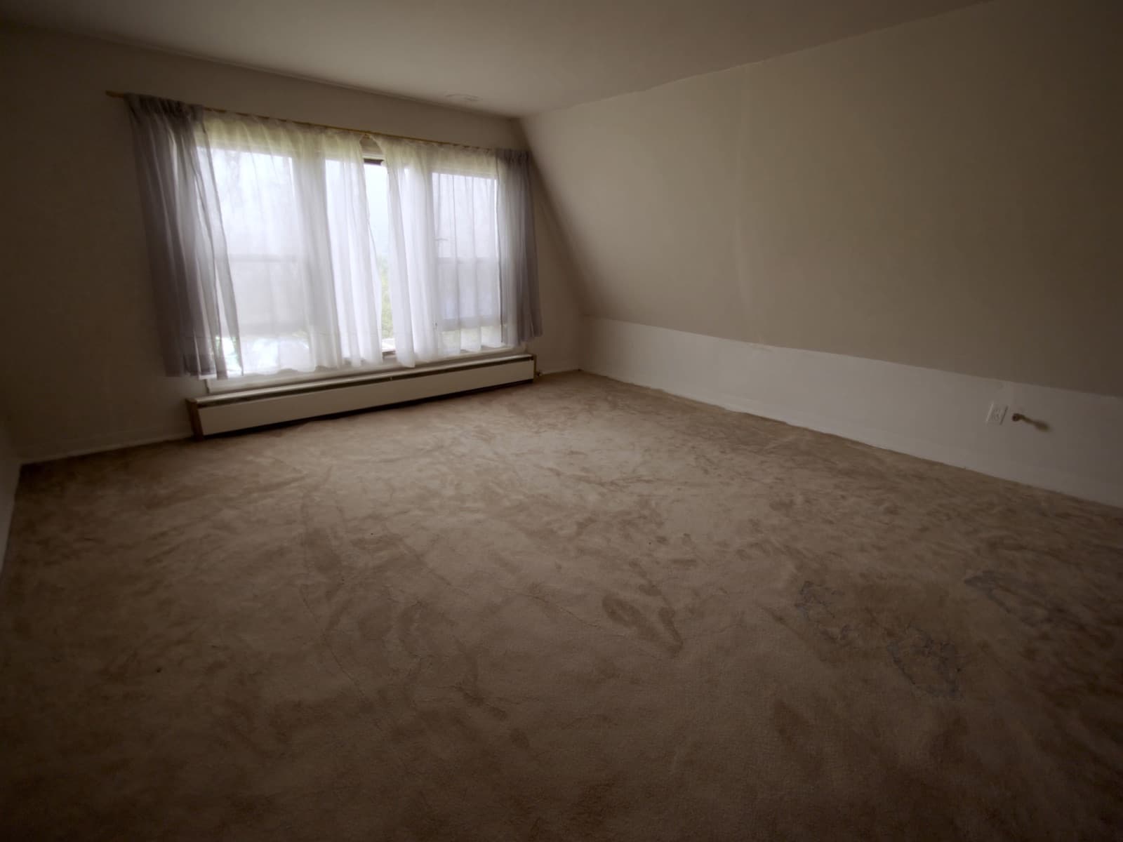 Living room with old flattened beige carpet