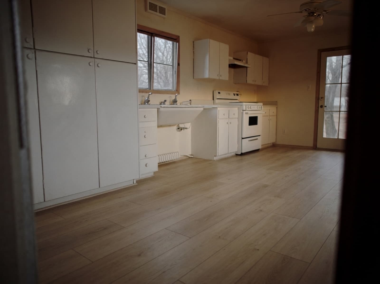 Same kitchen with new wide-plank luxury vinyl flooring