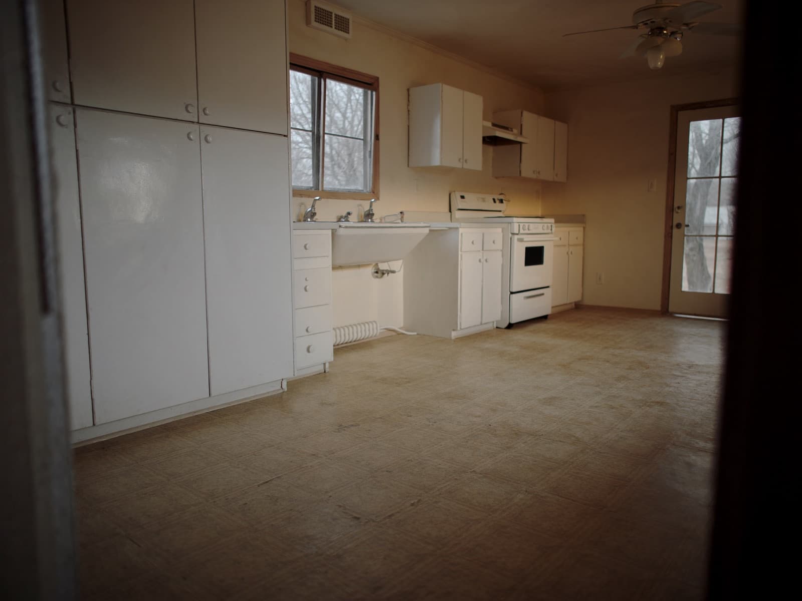 Kitchen with worn dated sheet vinyl flooring