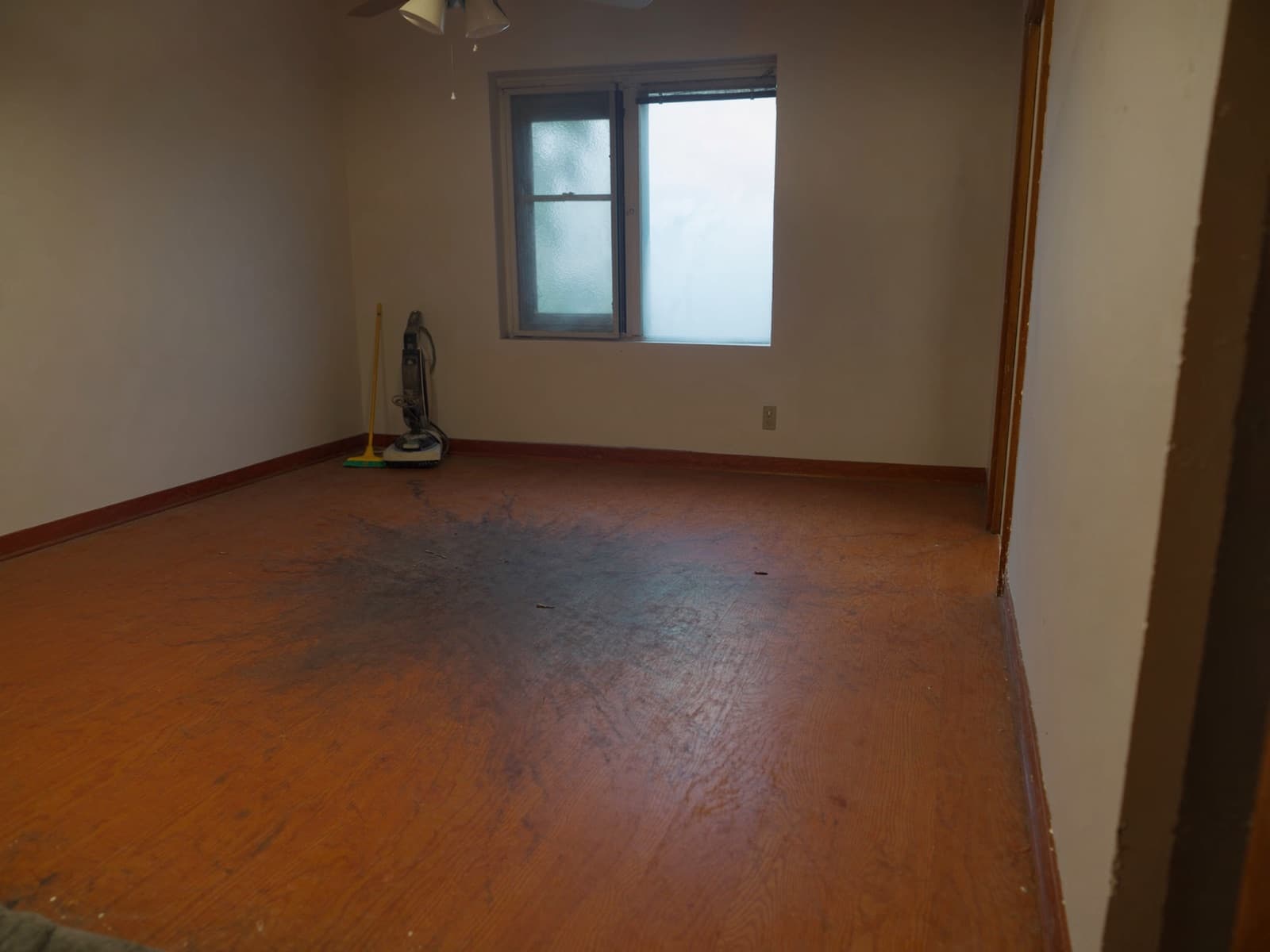 Bedroom with dated orange-toned hardwood, dull and scratched