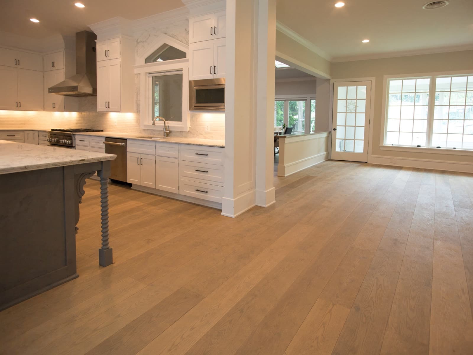 Kitchen with white cabinets and wide plank luxury vinyl flooring