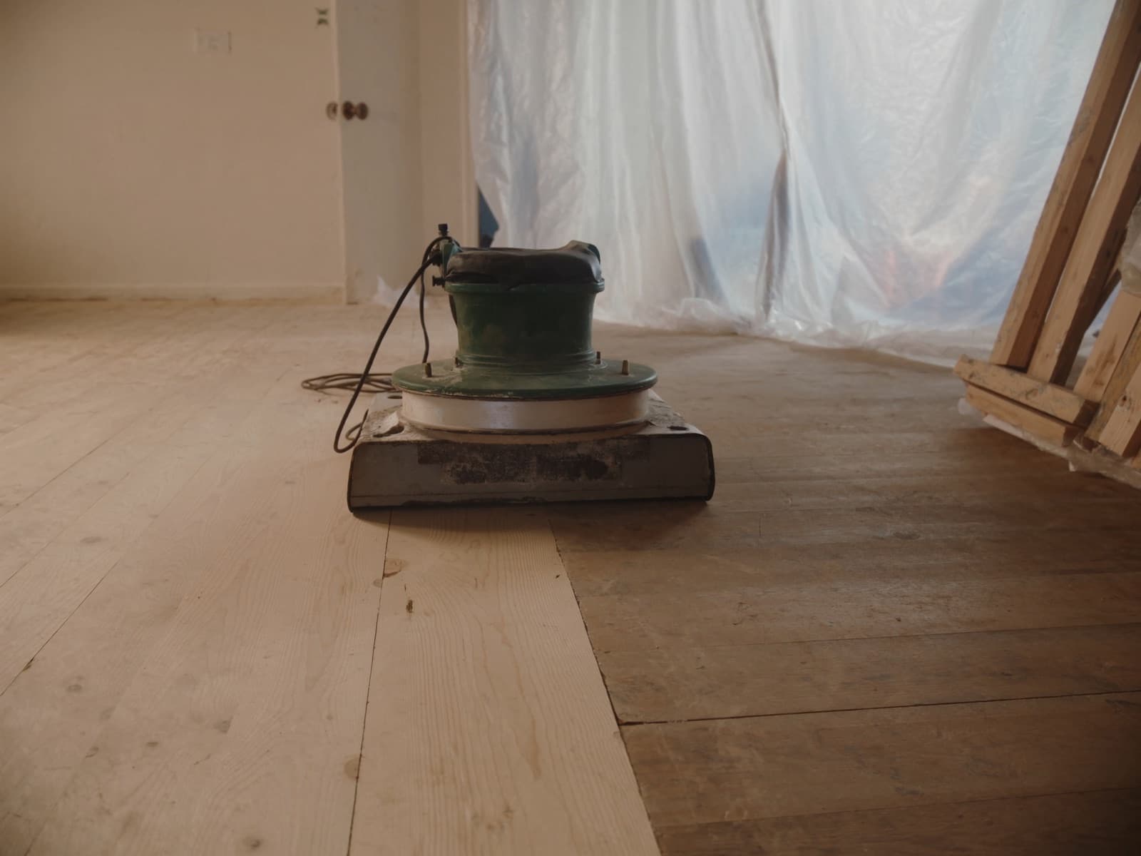 Floor buffer on partially sanded hardwood during refinishing